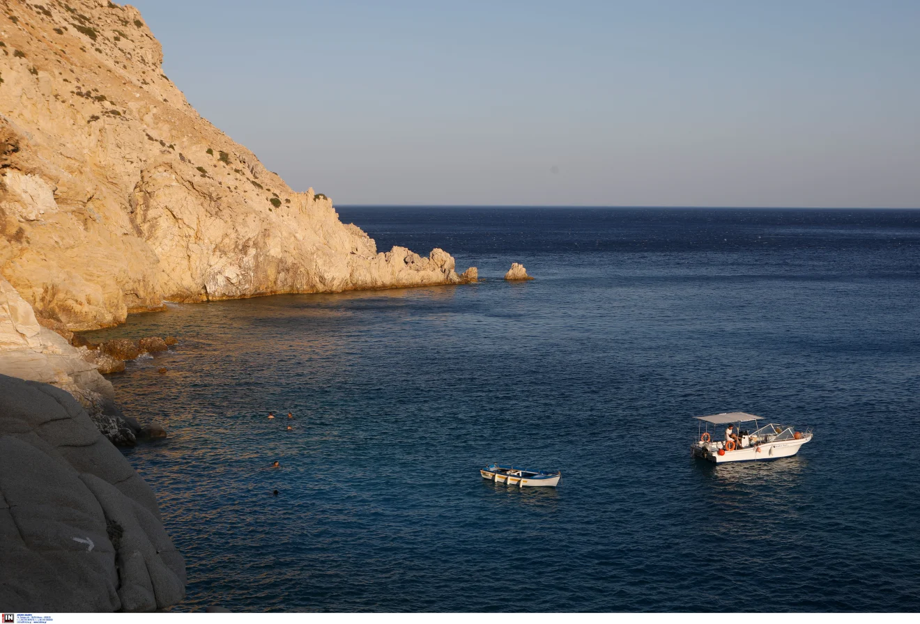 Βραχώδης παραλία με καθαρά νερά, λουόμενους και μικρά σκάφη ανοιχτά του κόλπου. Πηγή: ΙΝΤΙΜΕ.