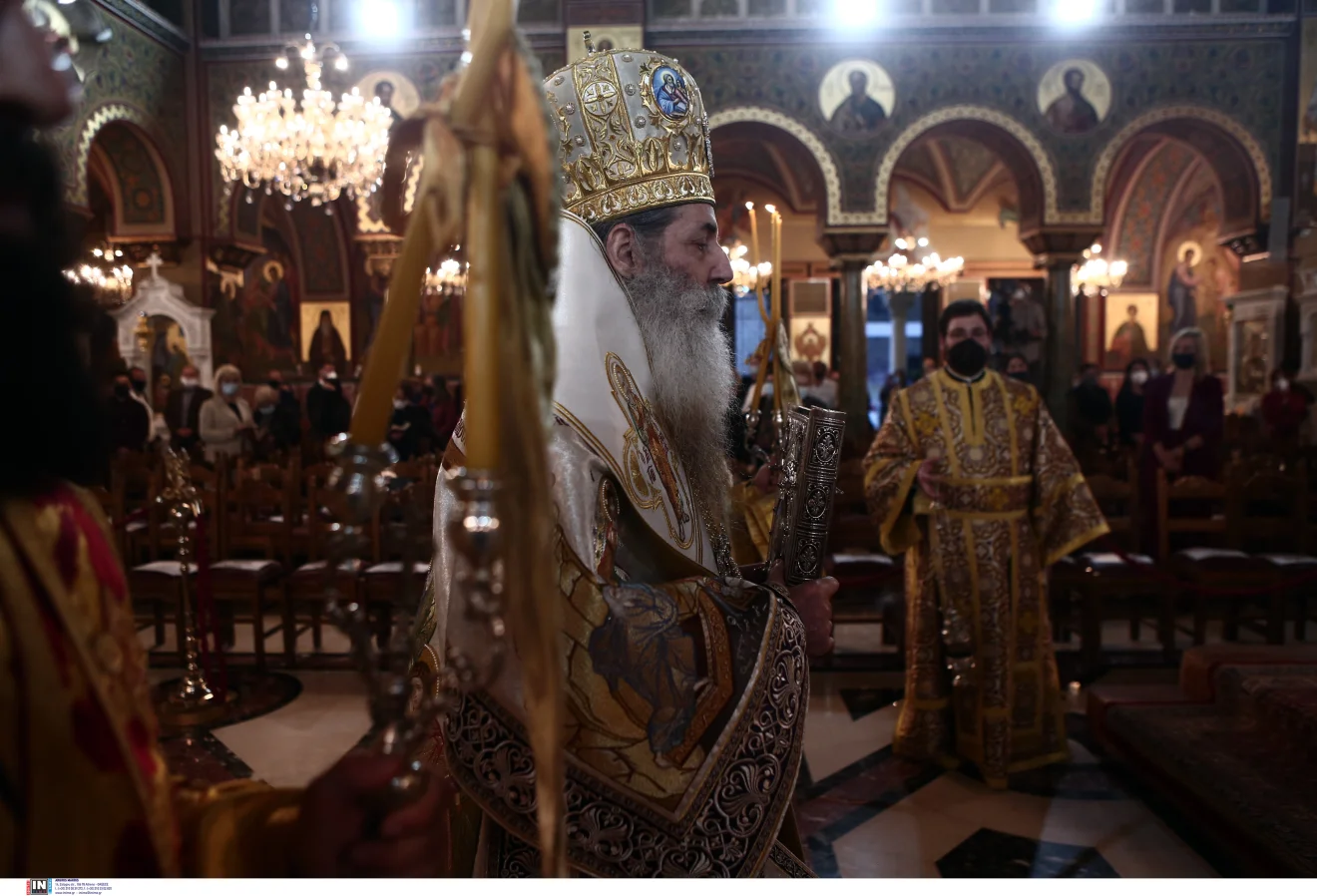 Περιγραφή εικόνας: Ορθόδοξη θρησκευτική ακολουθία στο εσωτερικό ναού, με ιεράρχη με αρχιερατικά άμφια, κληρικούς και πιστούς ανάμεσα σε αγιογραφίες και αναμμένους πολυελαίους. Πηγή: ΙΝΤΙΜΕ