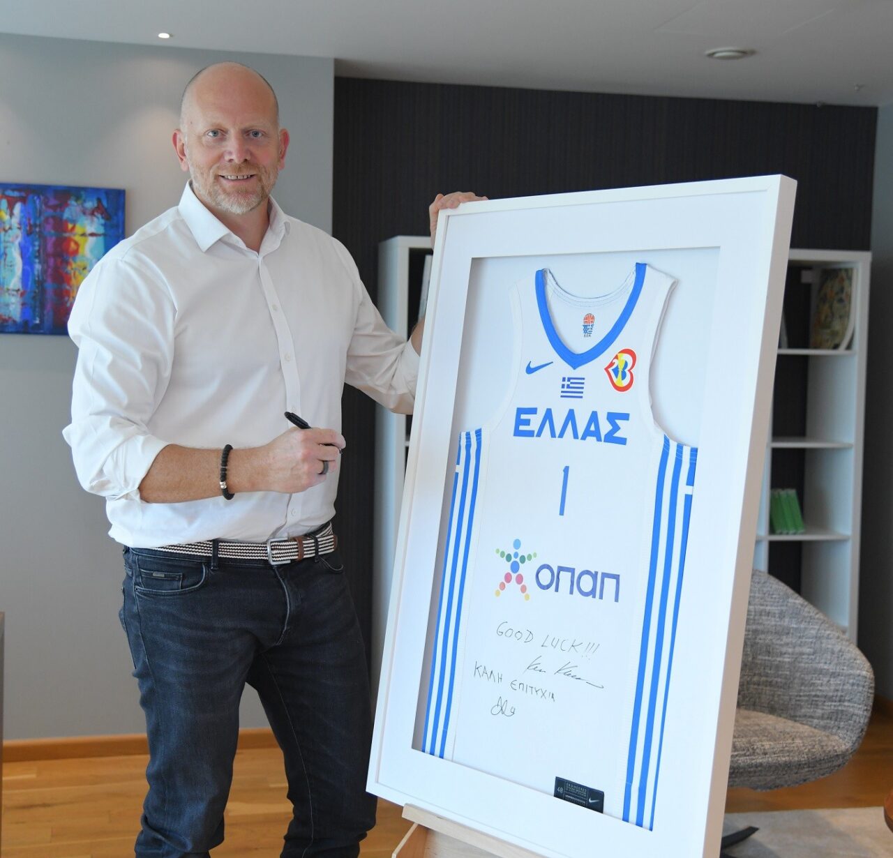 Ο Διευθύνων Σύμβουλος του ΟΠΑΠ, Jan Karas, υπογράφει τη φανέλα που δόθηκε ως δώρο στην Εθνική Ανδρών, από τη διοίκηση και τους εργαζόμενους του ΟΠΑΠ, για να της ευχηθούν «καλή επιτυχία» στο Παγκόσμιο Κύπελλο Μπάσκετ